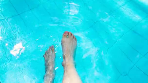 Αργή κίνηση των γυναικείων ποδιών που κρέμονται στην πισίνα — Αρχείο Βίντεο