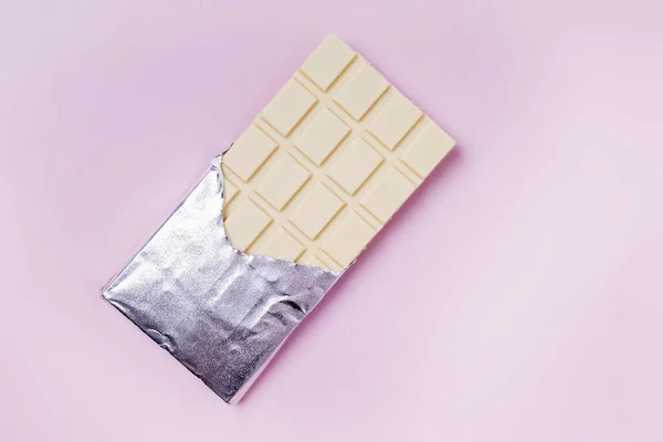 Chocolate branco em folha no fundo rosa — Fotografia de Stock