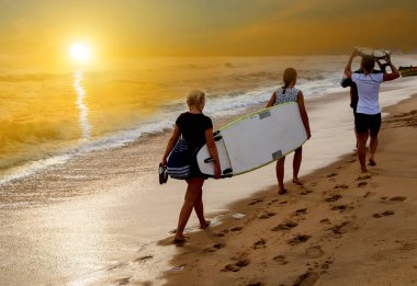 Dalgalar deniz Beach surfboard ile güneşin üzerinde çalışan sörfçü bikini