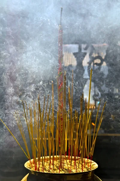 Burning Incense Sticks with smoke, joss sticks burning at a vintage Buddhist temple Chinese New Year ceremony