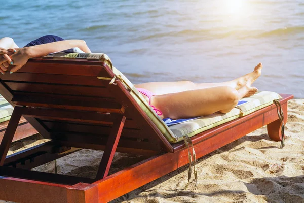 Sunbed woman tanned body on the beach