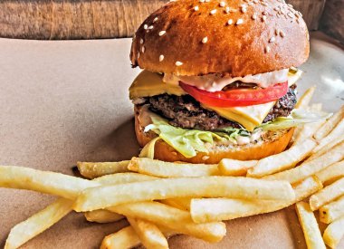Hamburger ve kızarmış patates ahşap masa arka plan