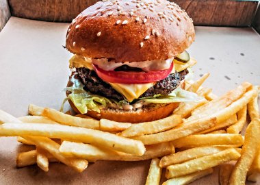 Hamburger ve kızarmış patates ahşap masa arka plan