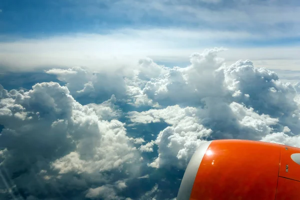 airplane porthole flying turbine above white clouds tropical