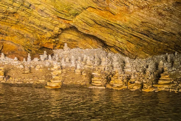 Pirámide de piedras para la meditación que yace en la costa del mar — Foto de Stock