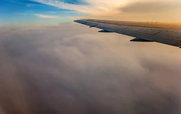 Křídlo letadla letícího nad mraky — Stock fotografie