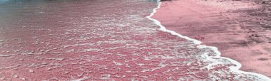Bahamalar Kum Kumsalı 'nın beyaz deniz köpüklü ayak izleri. Uzun boş tropikal kumlu, boş pembe kumlu sahil Bahamaları. Yaz dönemi. Kopyalama alanı, kumsalda ayak izleri yaz tatili.