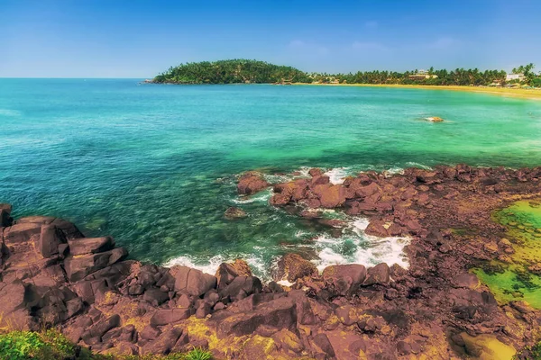 Parrot Rock with waves on sandy beach. Mirissa, Sri Lanka Horizon of the sea small waves at low tide