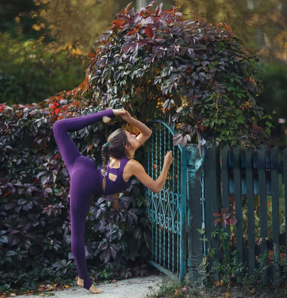 美丽的女人在秋天的花园里做瑜伽 — 图库照片