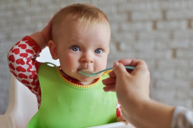 Mutfakta kaşıkla besleme bebek anne