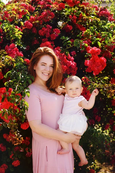 Vrouw Met Een Meisje Van Baby Buurt Van Rozenstruiken — Stockfoto