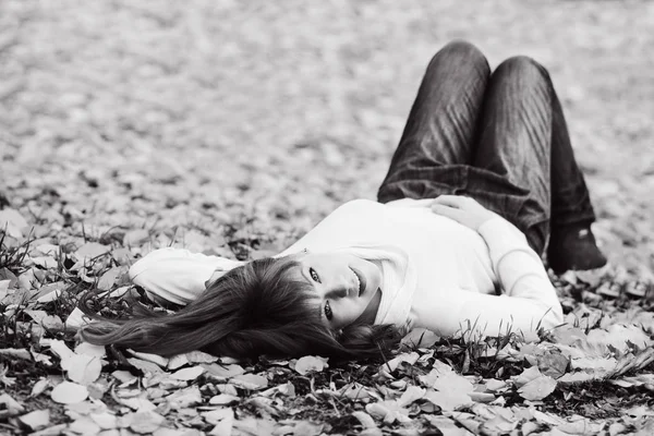 红发女孩躺在秋天的草地上 — 图库照片