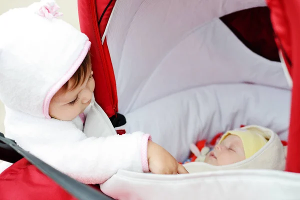 Menina Criança Curiosa Olhando Para Carrinho Com Bebê — Fotografia de Stock