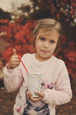 Ormanda yürüyüş ve sonbahar günü sıcak kakao içmeye küçük çocuk