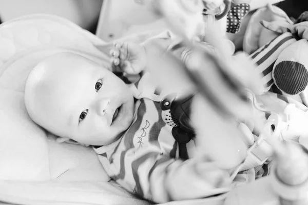 Baby Liegt Türsteherstuhl Und Spielt Spielzeug — Stockfoto