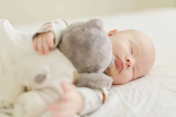 ベッドの上の熊と新生児が眠っています — ストック写真