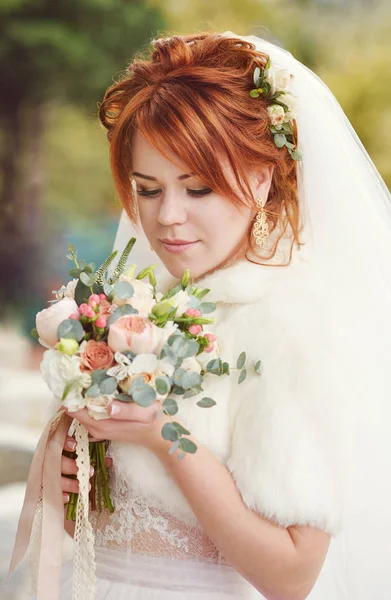 redhead pretty young bride with flowers in hands