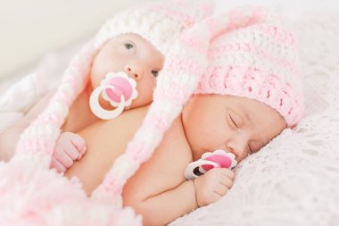 İki tatlı ikiz yatakta yatıyor.