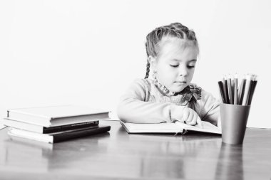 Kız masada oturan ve kitap okuma