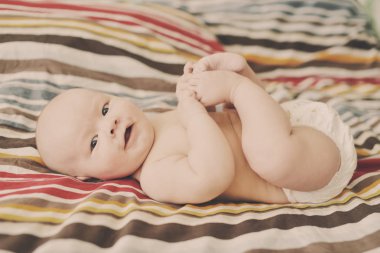 mutlu bebek döşeme ve kendi ayakları yakalamak