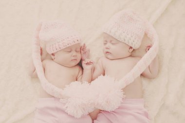 Uyuyan İkizler büyük ponpon ile komik şapka giymiş