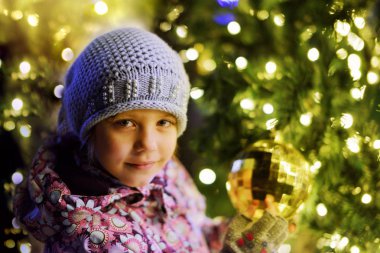 Açık havada Noel ağacı yanında küçük kız