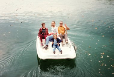 adam ve üç kız üzerinde göl kenarında pedal katamaran yelken