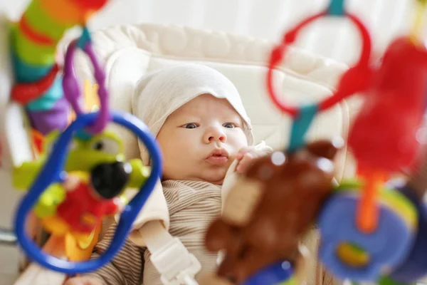 Förvånad Över Baby Fastställande Bouncer Stol Och Tittar Leksaker — Stockfoto