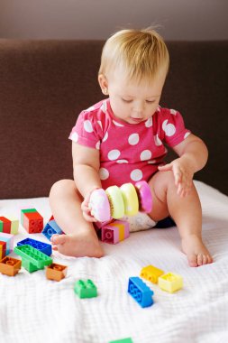 Renkli plastik blokları ile kapalı oynayan kız şirin bebek