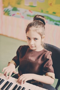 küçük kız piyanoda oynuyor