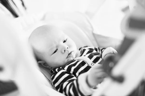 赤ちゃんの用心棒の椅子に敷設とおもちゃに触れる — ストック写真