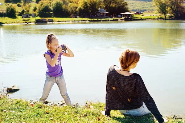 Девочка Подросток Фотографирует Свою Подругу Цифровой Камерой Возле Озера — стоковое фото