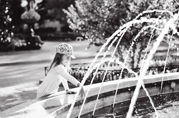 Girl playing with fountain water — Stock Photo, Image