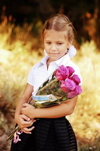 Schoolmeisje met bloemen — Stockfoto