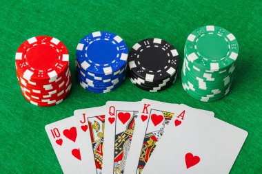 Kumarhane fişleri ve iskambil kağıtları yeşil masada - kumar geçmişi