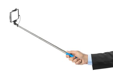 Beyaz arkaplanda izole edilmiş selfie çubuklu el ve akıllı telefon.