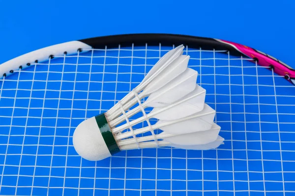 Badminton shuttlecock e raquete no fundo azul — Fotografia de Stock