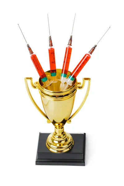 Golden trophy cup and syringes — Stock Photo, Image