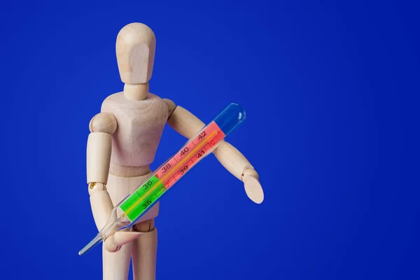 Figurine jouet en bois avec thermomètre sur bleu — Photo