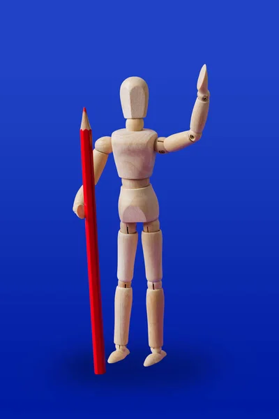 Wooden toy figure with pencil on blue — Stock Photo, Image