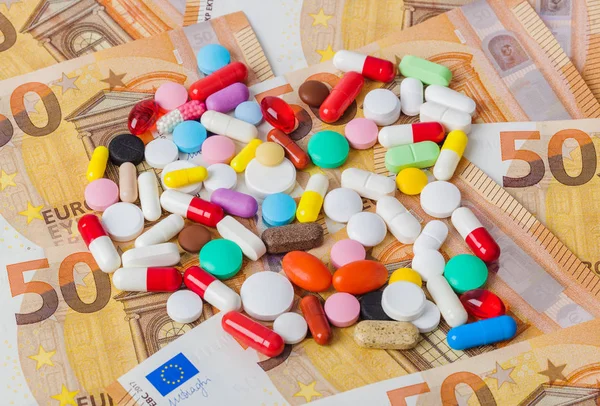 Pillen en geld - zakelijke medische achtergrond — Stockfoto