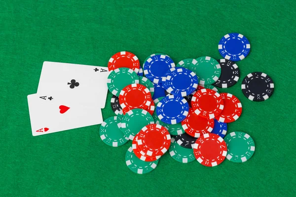 Casino chips en speelkaarten op groene tafel — Stockfoto