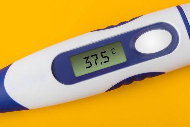 Elektronik tıbbi termometre (37.5 derece) sarı arkaplanda izole.