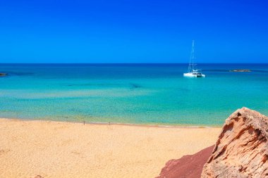 Cala del Pilar plaj sahne ile güneşli yaz gününde beyaz yat Menorca, İspanya.