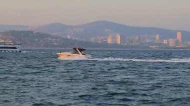 Motorlu tekne gün batımında hareket ediyor