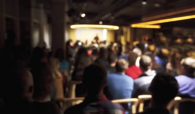 Bir sürü genç insan büyük bir salonda bir hoparlör dinleme