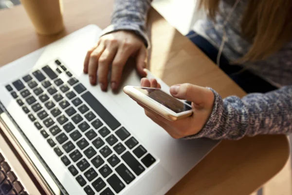 Jovem Está Sentada Mesa Com Laptop Moderno Usa Telefone — Fotografia de Stock