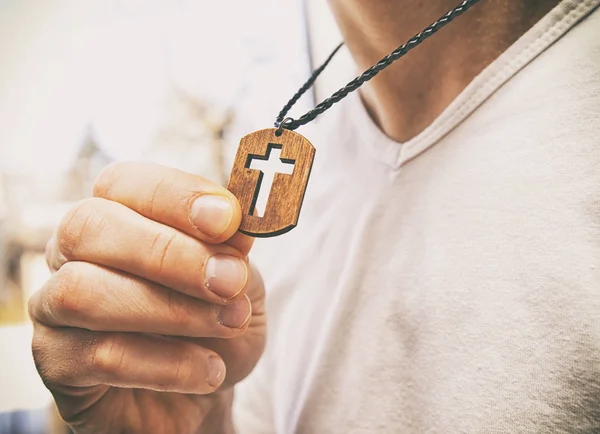 The wooden cross necklace on man\'s neck