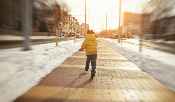 小男孩正在穿过冬天的林荫大道 — 图库照片