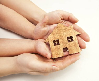 Kadın ve çocuğun küçük ahşap evde el. Gayrimenkul, sadaka, Aile ve ev fikir